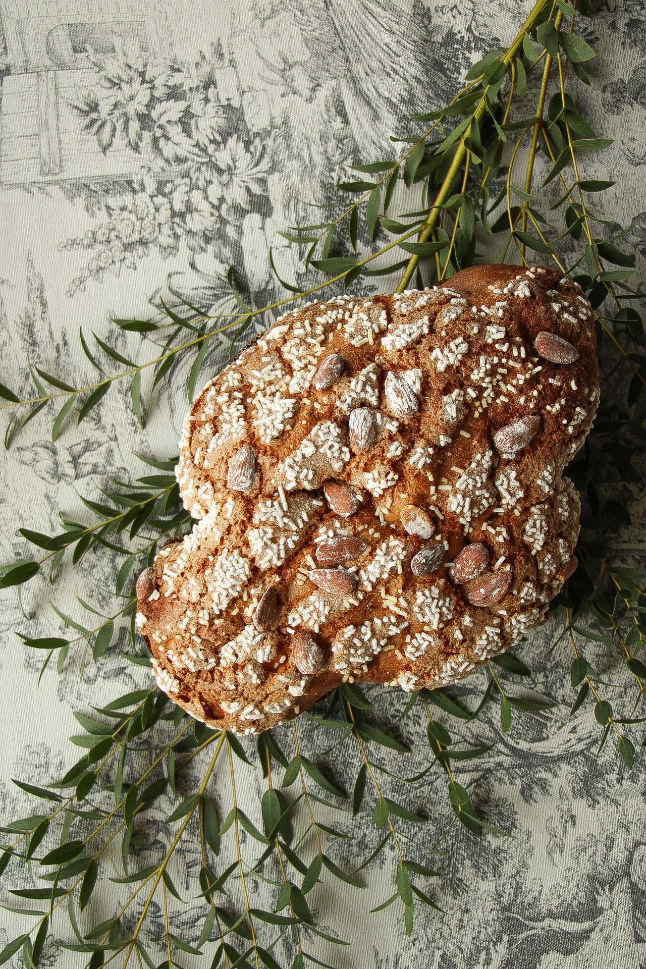 Colomba pasquale artigianale glassata con mandorle tra fiori di ciliegio