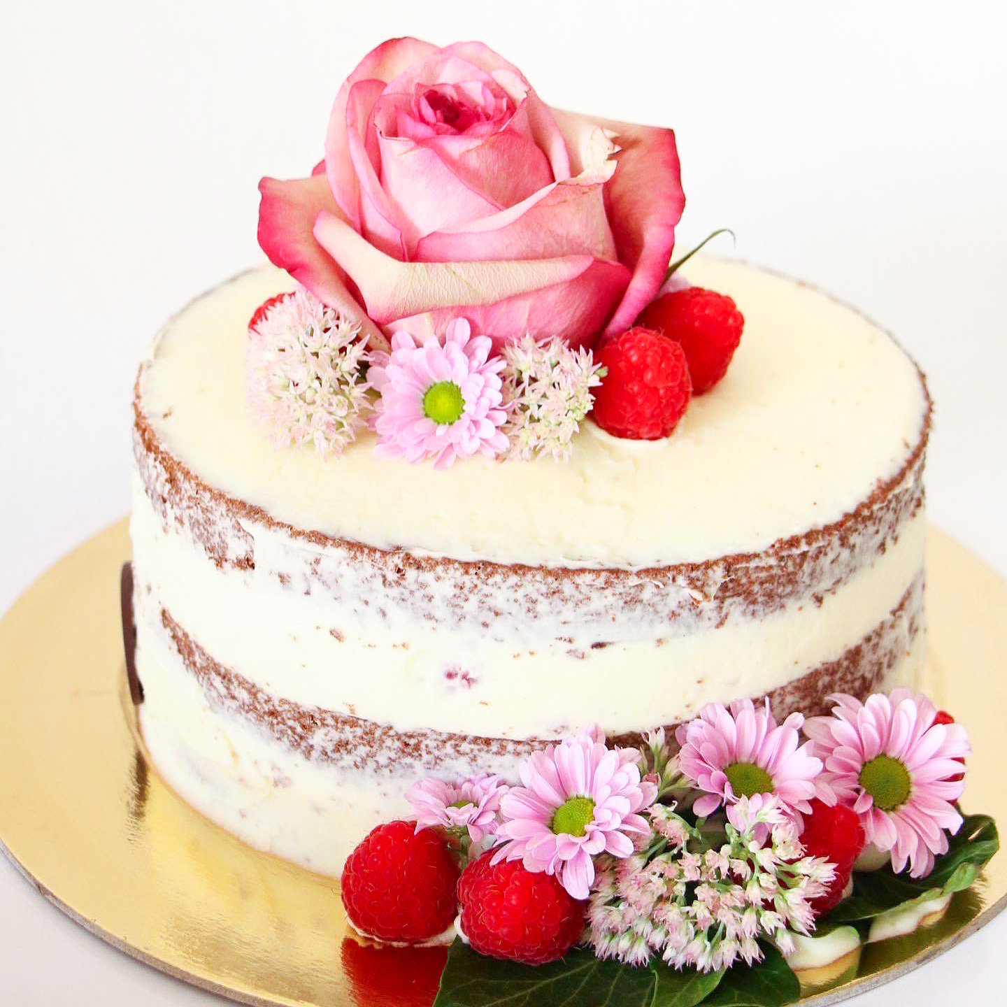 Torta realizzata su richiesta di un cliente, decorata con dei fiori freschi veri e dei fiori realizzati con la pasta di zucchero, lo stile della torta nacked le conferisce un certo dinamismo